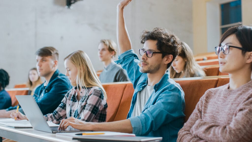 College student raising hand in classroom.